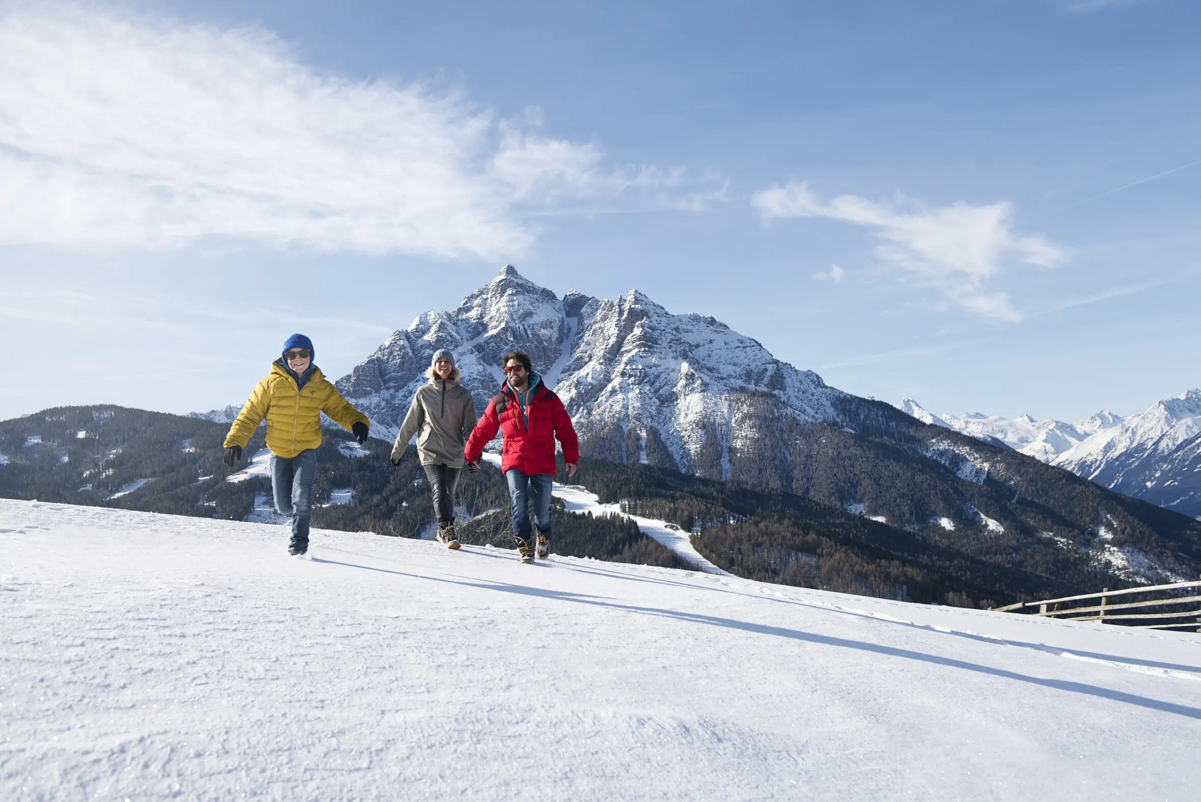 Familie mit Kindern im Schnee vor den Stubaier Bergen