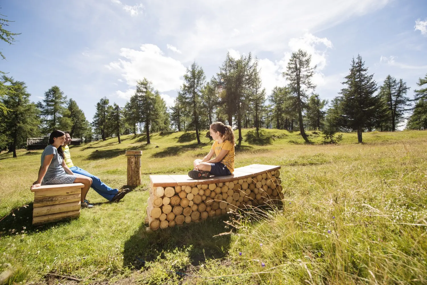 Zwei Personen auf Holzliegen am Naturschauplatz Eulenwiesen