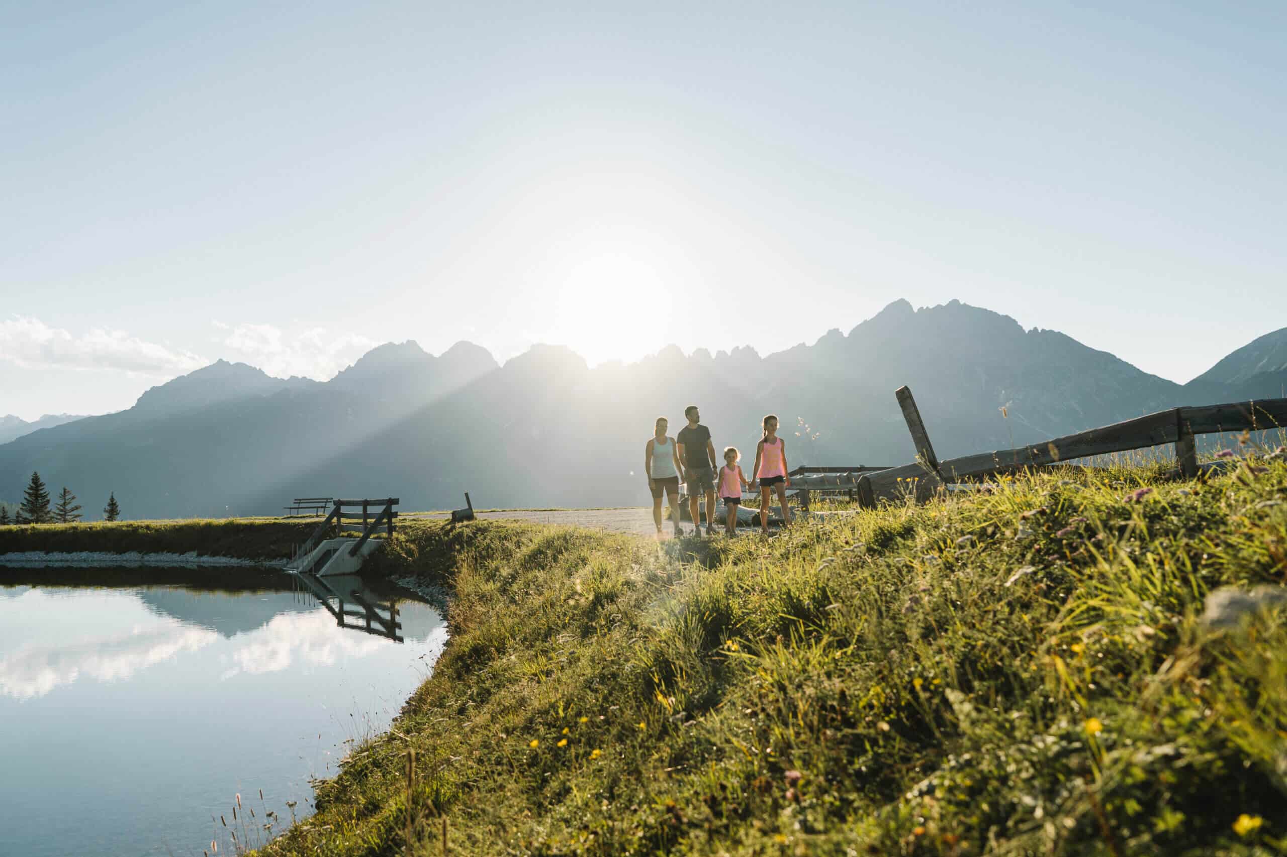 Wanderer an einem Bergsee bei den Serlesbahnen Mieders im Gegenlicht