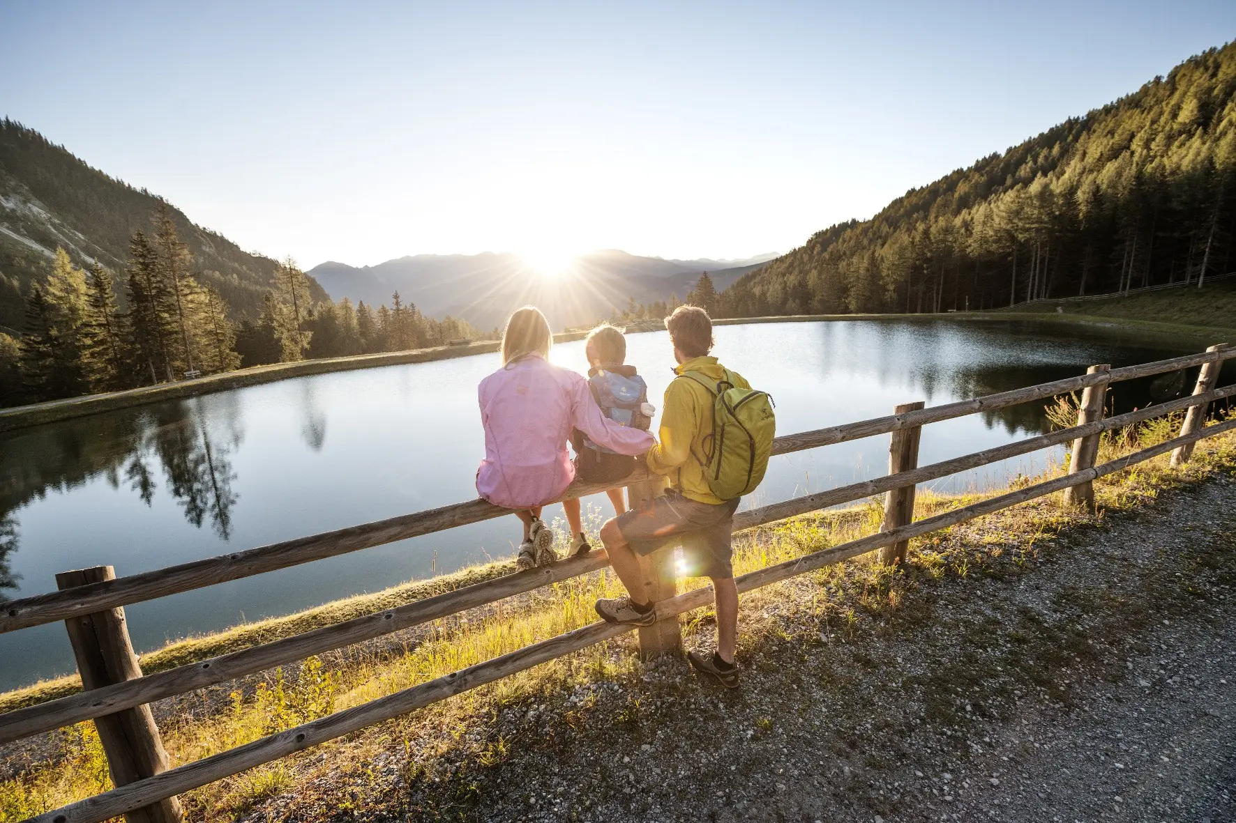 Familie am Ufer eines Bergsees im Abendlicht