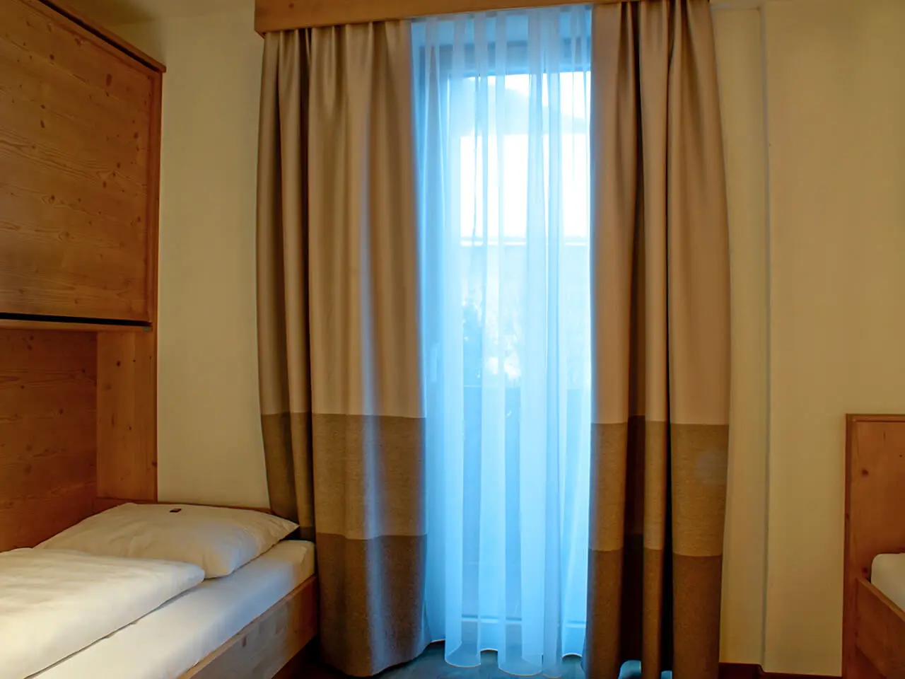 Zimmer mit getrennten Betten und Stockbett im Appartement König Serles